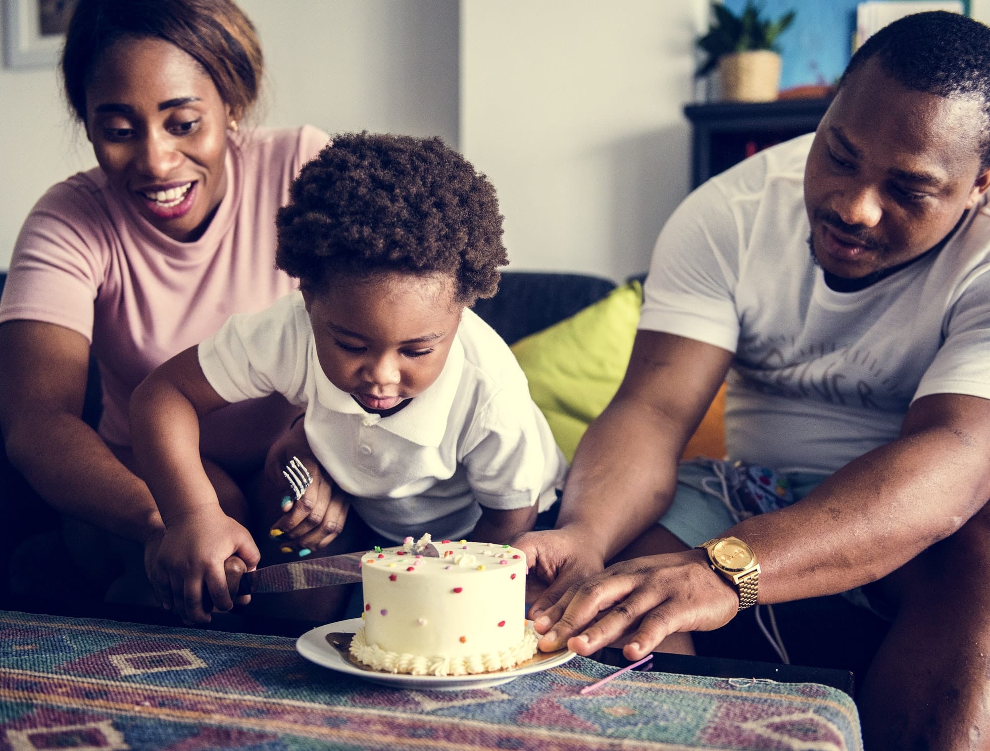 Black family cutting birthday cake